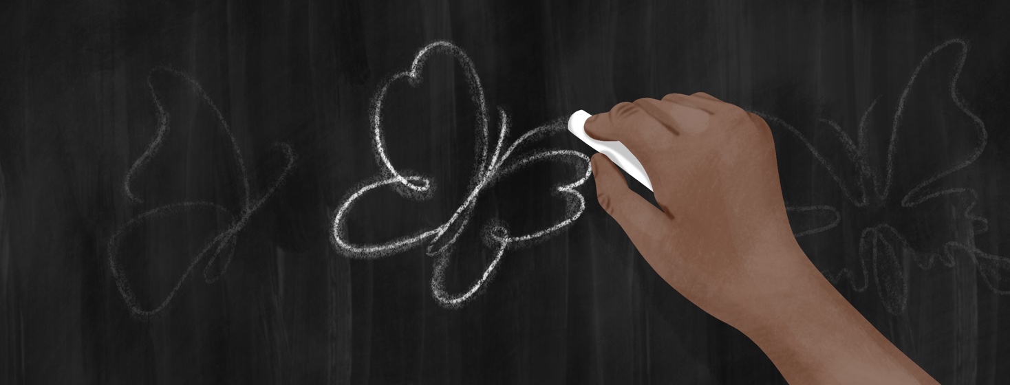 A hand draws a butterfly in chalk on a chalkboard.