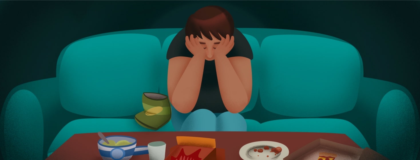 A man sits looking defeated on the couch with his head in his hands, surrounding him are eaten through containers of food. Chips, soda, pizza, ice cream, snacks, sweets, eating disorder, caucasian, regret